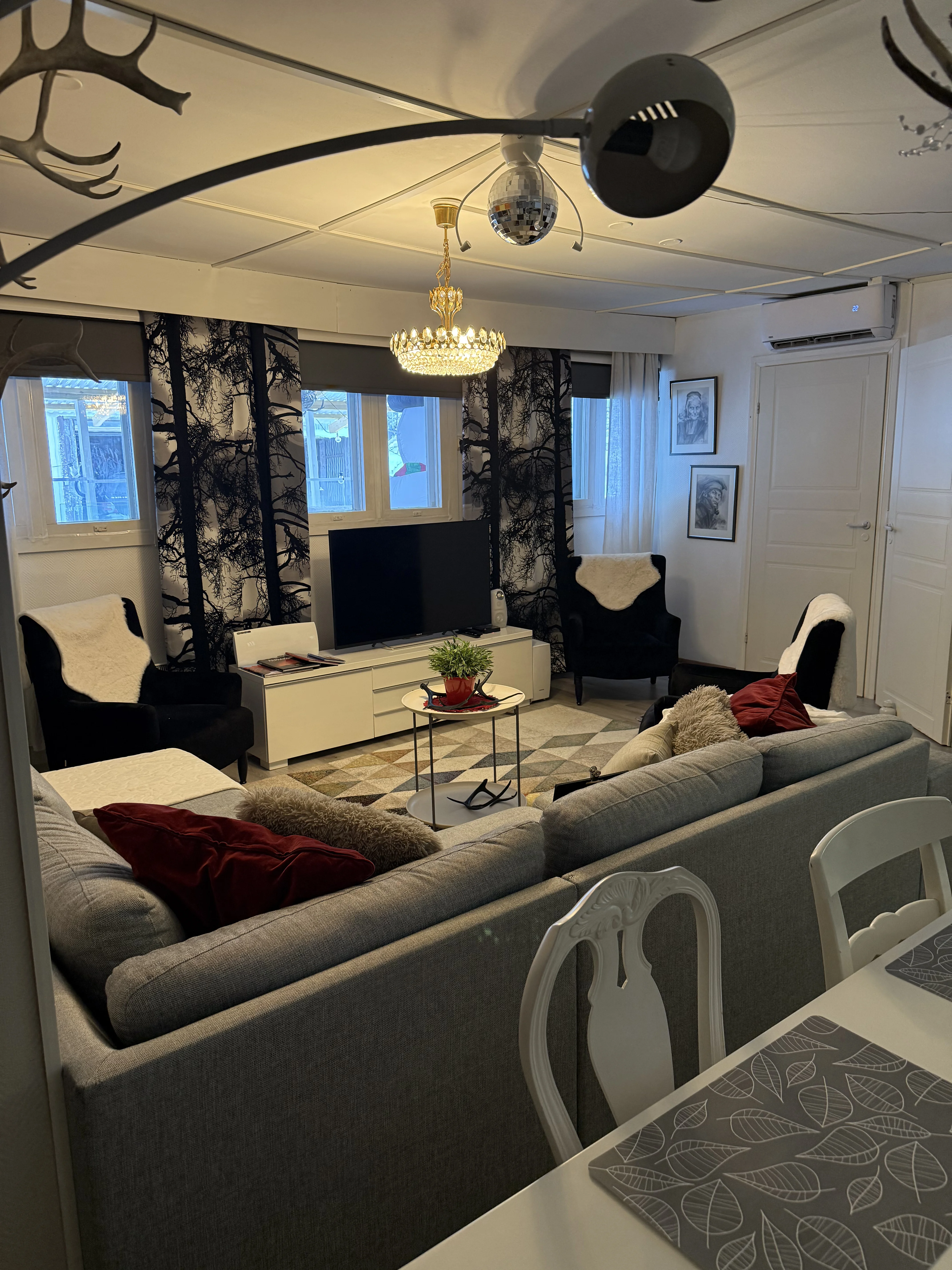 The living room with sofas, armchairs and a wall-mounted flat-screen TV